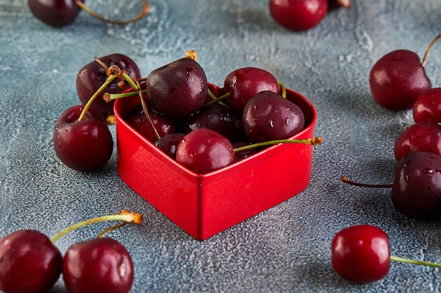 Fresh Cherry or sweet cherry with water drops with a red heart. Concept for valentines day