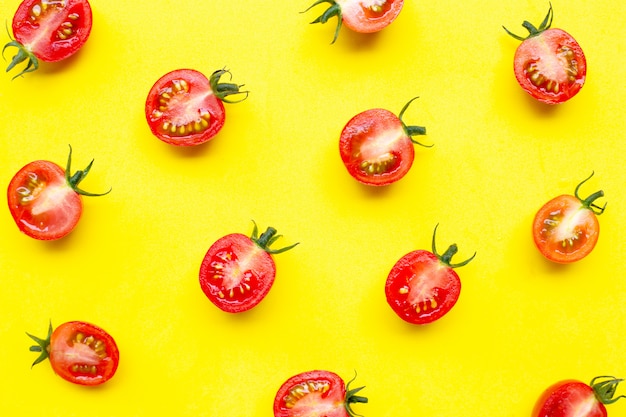 Fresh cherry tomatoes, half cut isolated on yellow background.