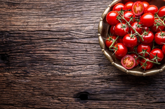 Fresh cherry tomatoes. Ripe tomatoes on oak wooden background.