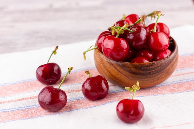 Fresh cherry on white wooden table. Ripe sweet berries in droplets of water