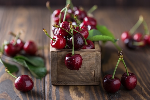 Fresh cherry with water drops on rustic wooden table.