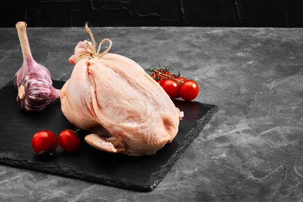 Fresh chicken carcass on a gray background fresh meat copy space photo for grocery stores dark