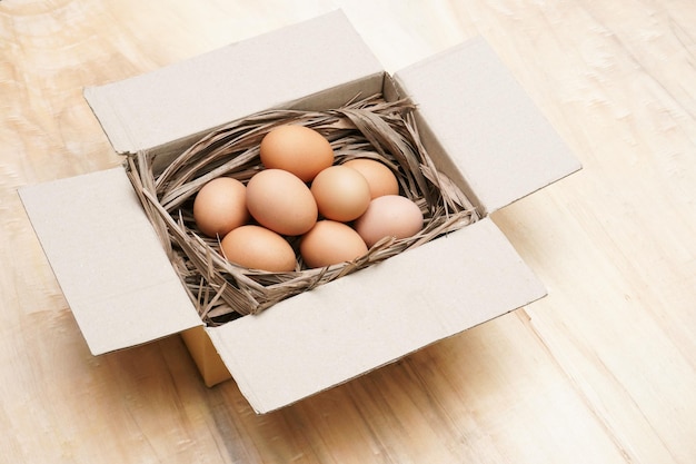 Fresh chicken eggs in paper box on the wooden table