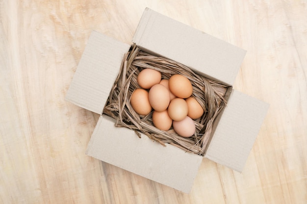 Fresh chicken eggs in paper box on the wooden table