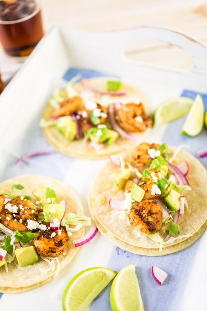 Fresh chipotle shrimp tacos with cotija cheese on a white corn tortillas.