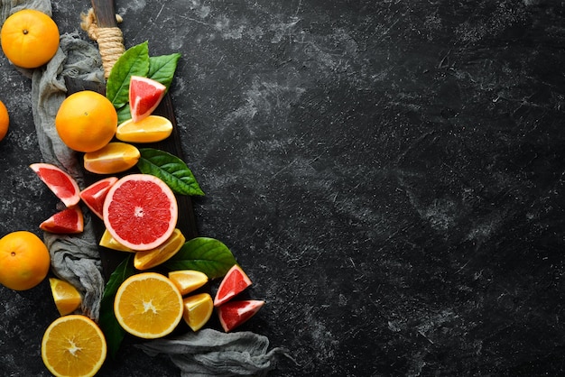 Fresh citrus fruits on black stone background Top view Free copy space