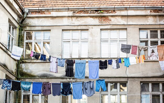 Fresh clean clothes are drying outside. Clothes hanging to dry on a clothes-line. Laundry dryings on the rope. Washed clothes drying outside of an old house. Washed clothes drying.