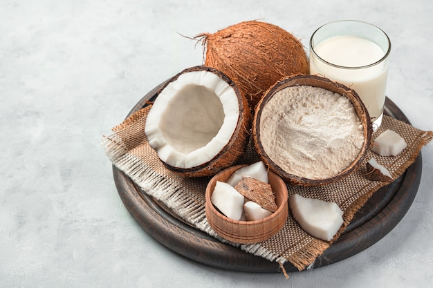 Fresh coconut and coconut products on a gray background. Coconut flour and coconut milk.