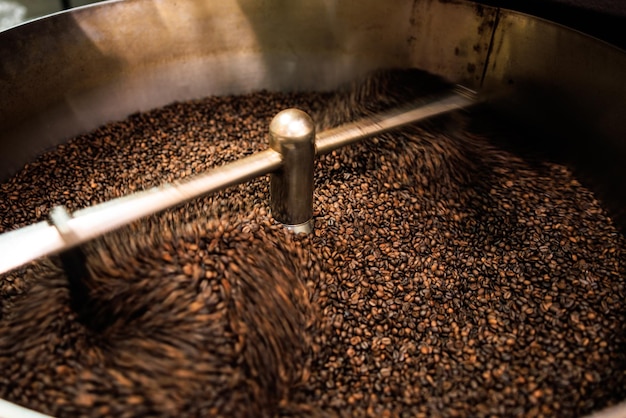 fresh coffee beans roasted spinning cover professional machine close up to soft focus slow shutter