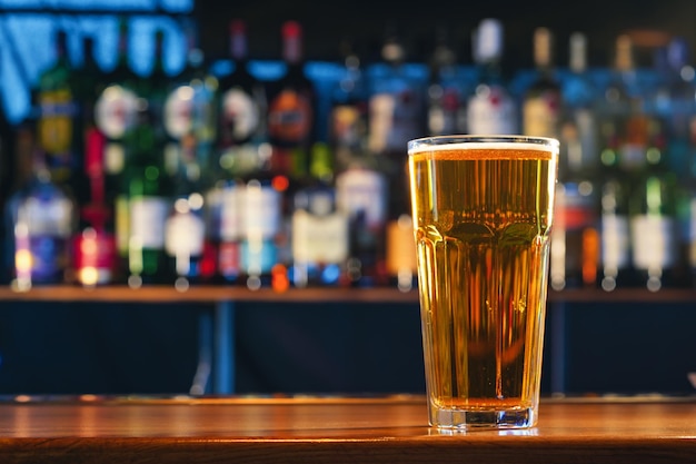 Fresh cold beer in glass on bar background