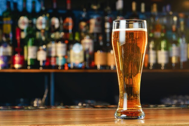 Fresh cold beer in glass on bar background