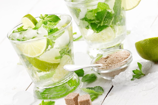 Fresh cold lime mojito on white table