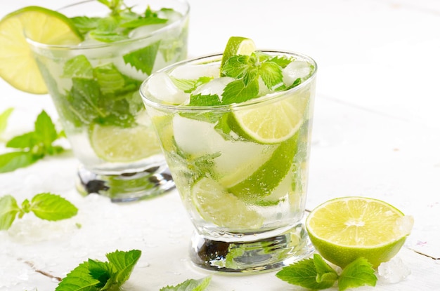 Fresh cold lime mojito on white table