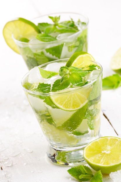 Fresh cold lime mojito on white table