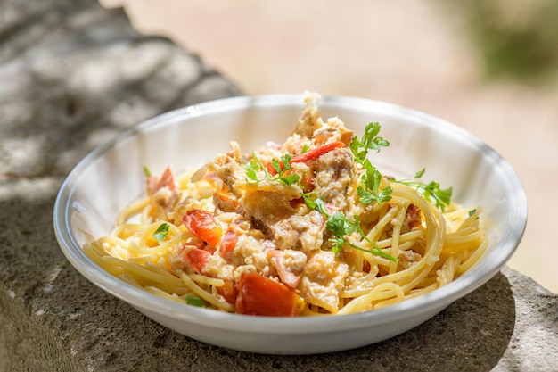 Fresh cooked spaghetti with edible brown sea crab also known as Cancer Pagurus by Mediterranean Sea on white plate