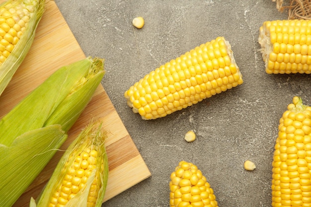 Fresh corn on cobs on grey background Top view