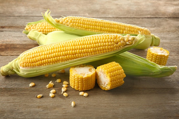 Fresh corn cobs on wooden table