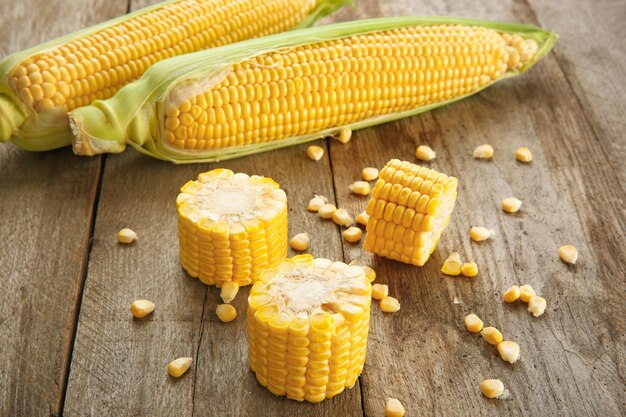 Fresh corn cobs on wooden table