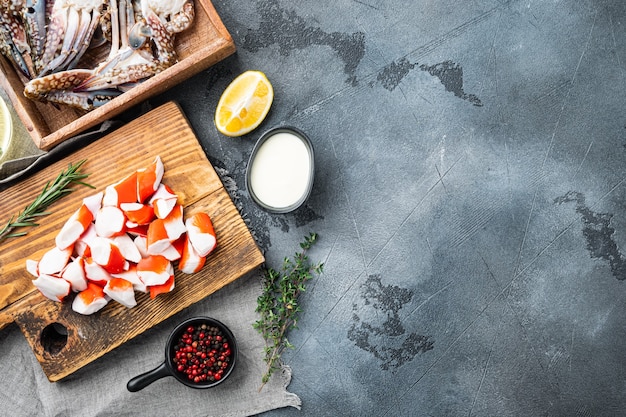 Fresh Crab meat stick surimi with blue swimming crab set, on gray table, top view flat lay