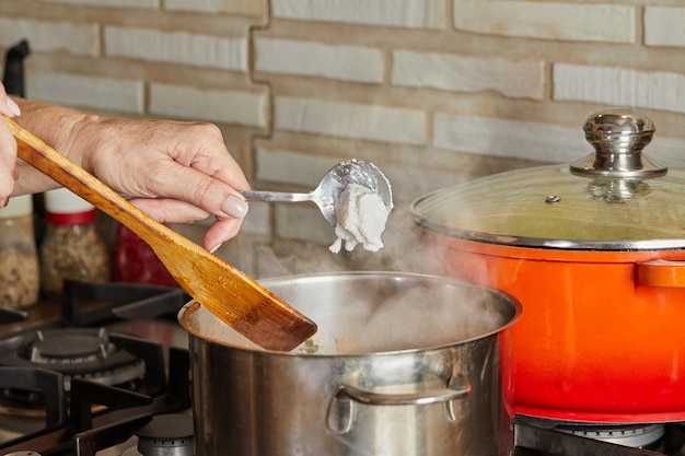 Fresh cream is thrown into pan on gas stove according to recipe from the Internet Steam pot