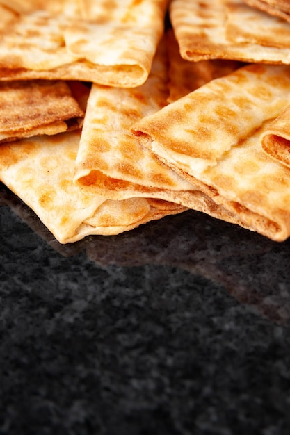 Fresh crispy biscuits stacked on black marble Freshly baked cookies Selective soft focus