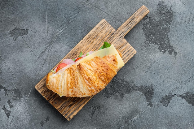 Fresh croissant or sandwich with salad, ham, jamon, prosciutto set, on gray stone background, top view flat lay, with copy space for text