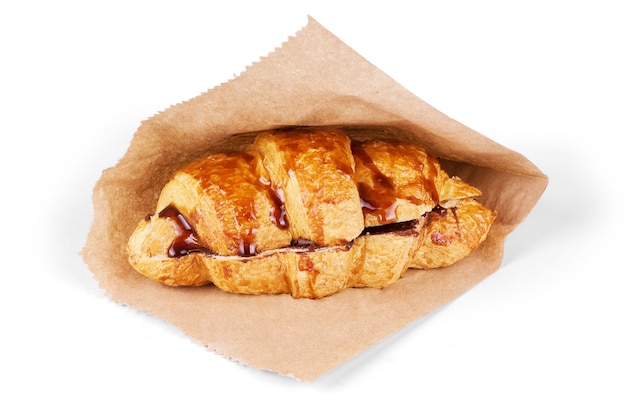 Fresh croissant with hot chocolate on a white background.