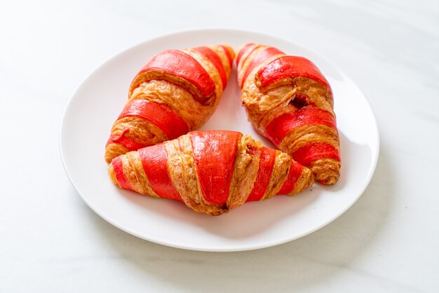 fresh croissant with strawberry jam sauce on plate