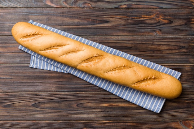 Fresh crunchy french baguette on colored table Top view Bakery products