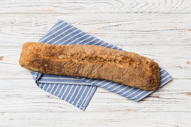 Fresh crunchy french baguette on colored table Top view Bakery products