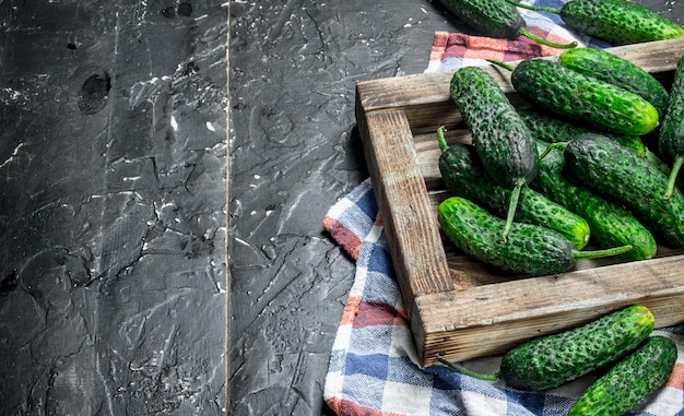 Fresh cucumbers on a wooden tray with a napkin