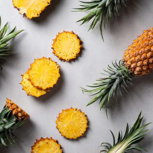 Fresh cut pineapple with tropical leaves on dark blue background