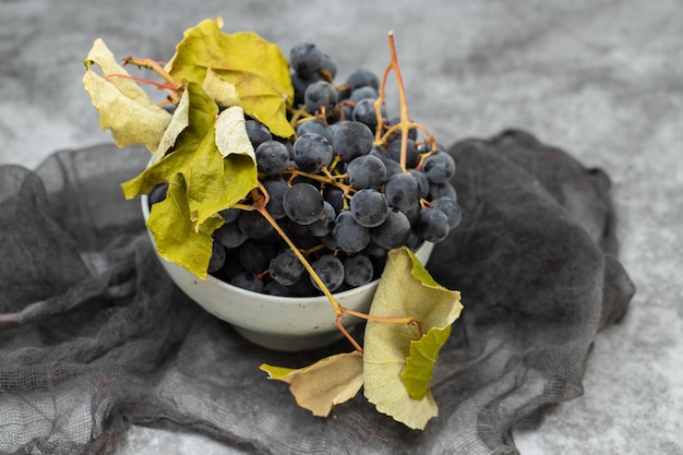 Fresh Dark blue purple grape in plate on grey background