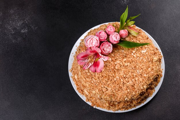 Fresh delicious cake napoleon with cream on a dark background. Cake consisting of cords and cream