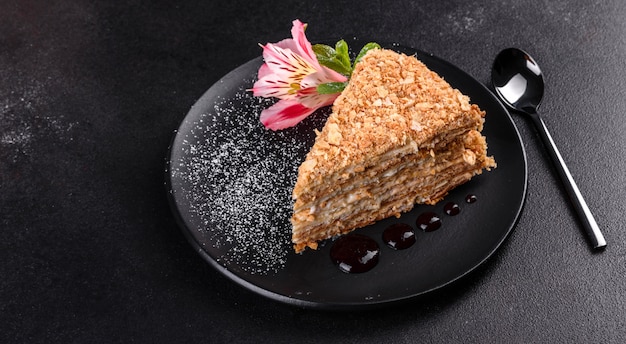 Fresh delicious cake napoleon with cream on a dark background. Cake consisting of cords and cream