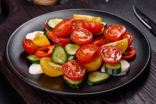 Fresh delicious salad with cherry tomatoes cucumbers sweet peppers cheese and olive oil