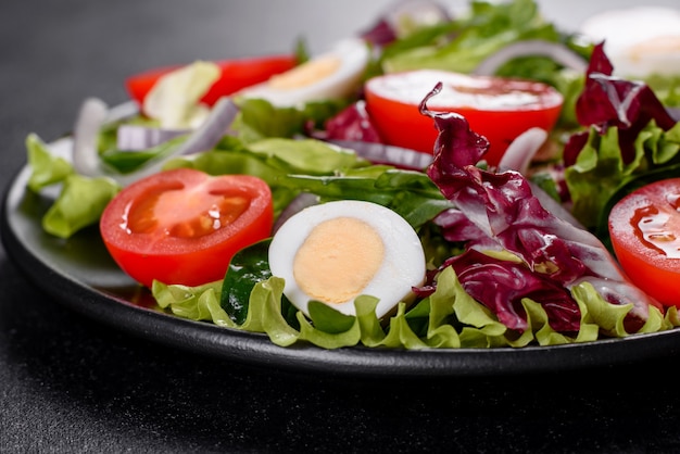 Fresh delicious vegitarian salad of chopped vegetables on a plate on a dark concrete background