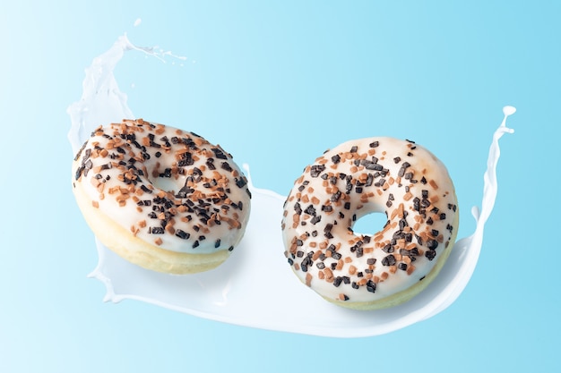 Fresh donuts with milk splashes on blue background