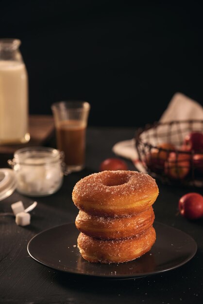 Fresh donuts with sugar powder and coffee with milk on a wooden table Breakfast in the village