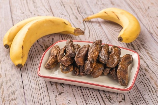 Fresh and dried bananas on a rustic wooden table Delicious natural fruit snack