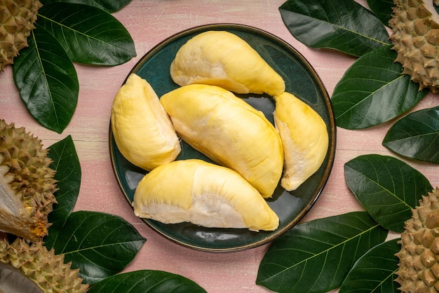 Fresh Durian fruit on black plate Durian fruit with peel the King of fruits on wooden background