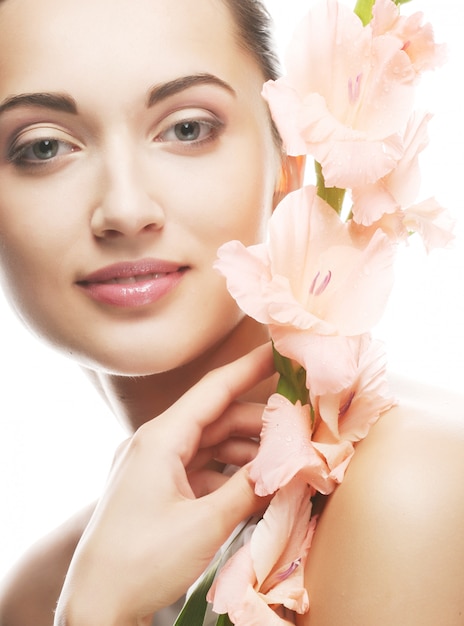 Fresh face with gladiolus flowers in her hands