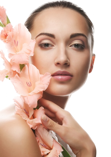 Fresh face with gladiolus flowers in her hands 