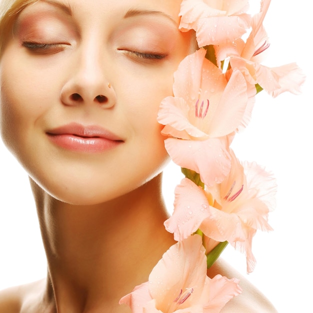 Fresh face with gladiolus flowers in her hands