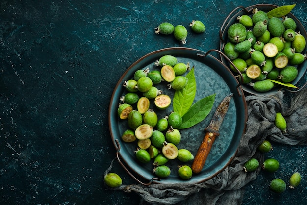 Fresh feijoa fruits on a wooden board Fruits are rich in iodine Top view on a black stone background