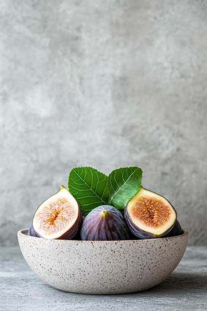 Photo fresh figs with green leaves in a ceramic bowl