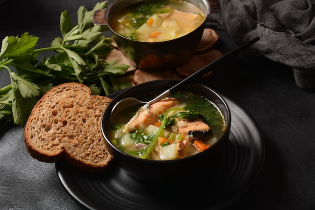 Fresh  fish soup on black background Salmon soup