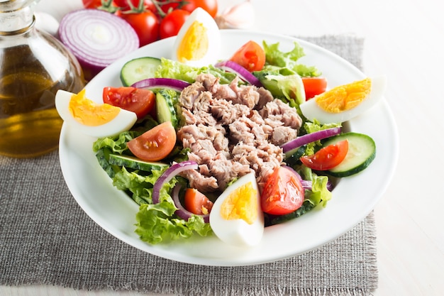 Fresh fish tuna salad made of tomato, ruccola, tuna, eggs, arugula, crackers and spices. 