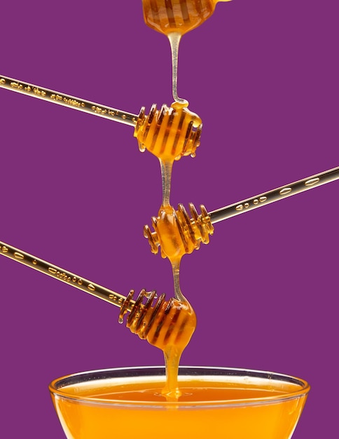 Fresh floral honey drips from a spoon into a spoon on a colored background Organic vitamin food