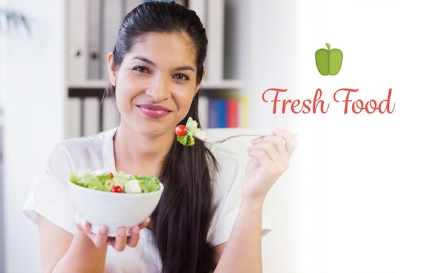 Fresh food against businesswoman eating salad in office